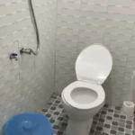 Baño con inodoro occidental y cubo tradicional mandi en Homestay Gracia