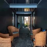 Pasillo interior con zona de descanso de mimbre en Paisupok Lodge