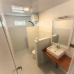 Baño privado con lavabo moderno y espejo en Paisupok Lodge cerca de Paisu Pok