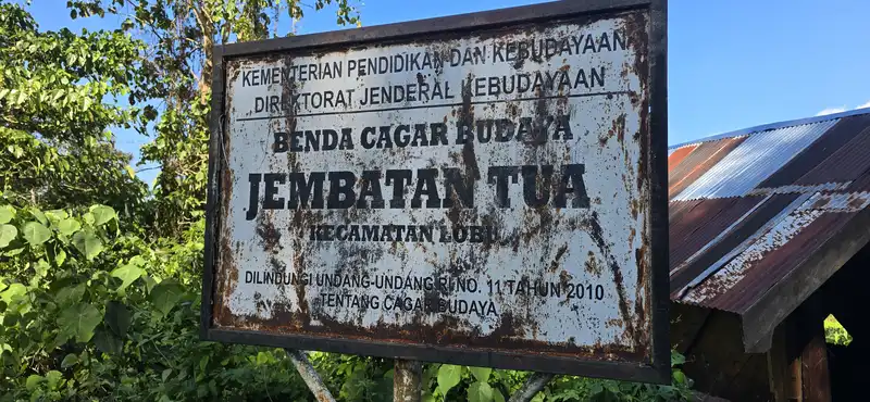 Cartel oficial de Patrimonio Cultural Benda Cagar Budaya del histórico puente colonial Jembatan Tua en Lobu.