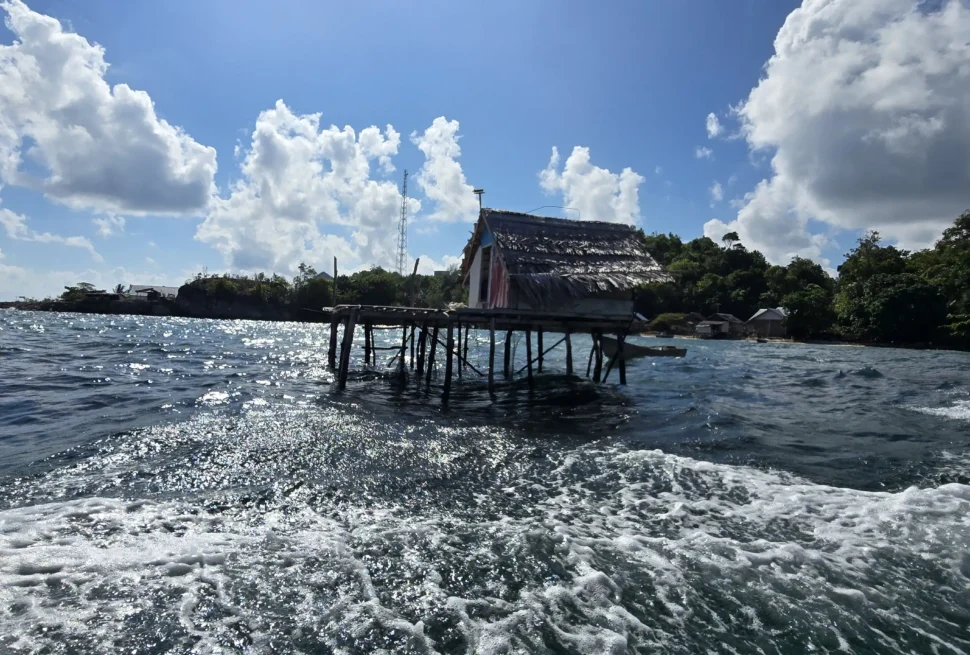 Vista frontal de una casa tradicional de madera Bajau sobre pilotes, construida sobre las aguas de Indonesia