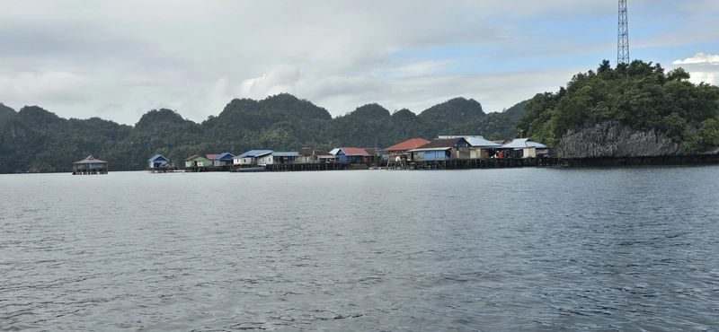 Vista panorámica de la aldea tradicional del pueblo Bajau sobre palafitos de madera en la laguna kárstica de Sombori, Sulawesi.