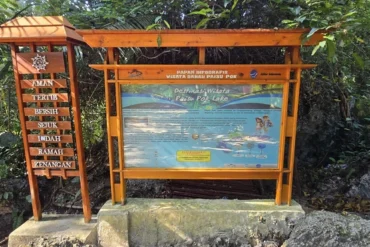 Cartel informativo de madera en la entrada principal del lago Paisu Pok.