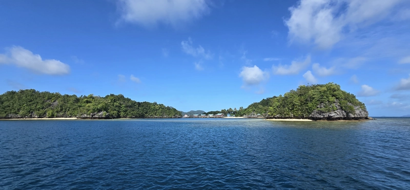 Vista panorámica de un asentamiento flotante tradicional de la comunidad Bajau sobre la costa de una isla en el mar de Sulawesi.