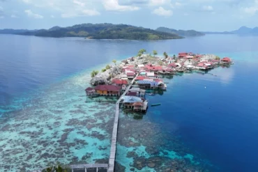 Vista aérea cenital con dron de la isla paradisíaca de Pulau Panpan y sus arrecifes de coral en el archipiélago de Sulawesi.
